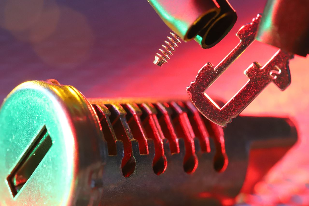 services-05 Macro shot of a mechanical lock cylinder and key, highlighting detailed components under vibrant lighting.