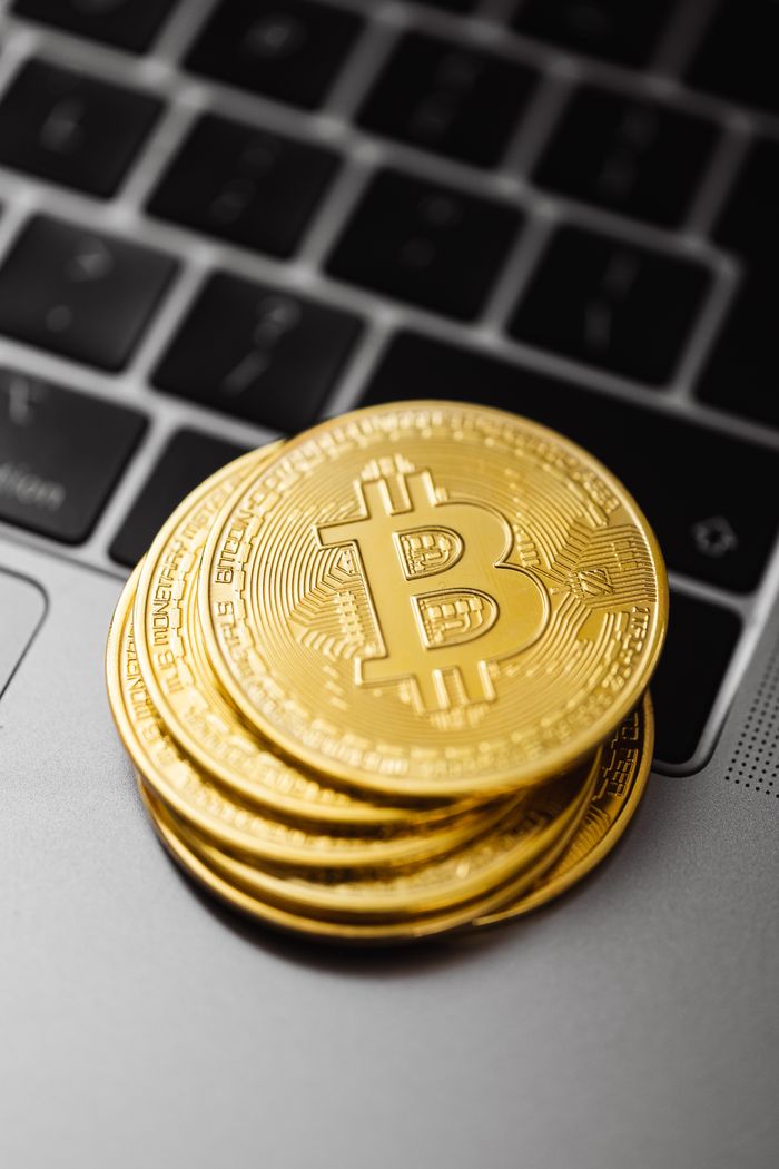 services-05 Close-up of physical Bitcoin coins stacked on a laptop keyboard, symbolizing modern cryptocurrency and technology.